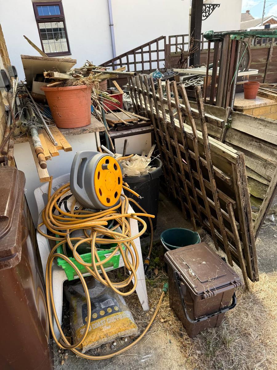 Cluttered side yard before clearance